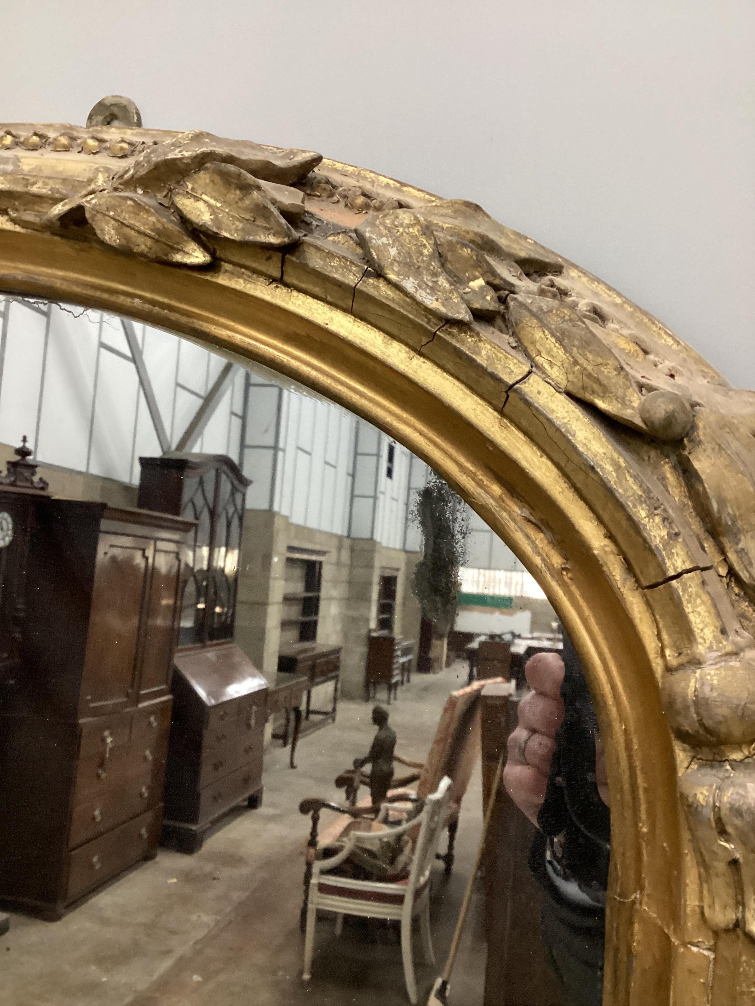 A Victorian giltwood and composition overmantel mirror with cartouche pediment, width 140cm, height 201cm. Condition - fair, three areas of lost gesso